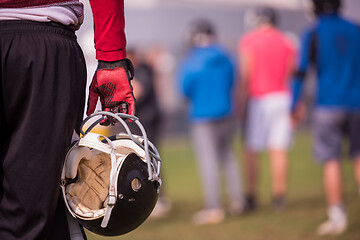 Image showing American football player holding helmet