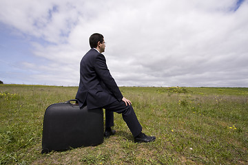Image showing businessman sit in his baggage 