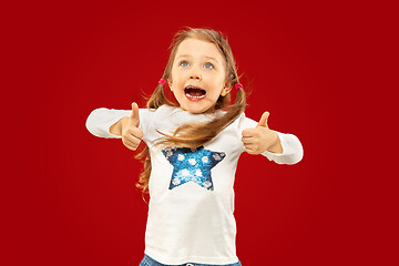 Image showing Beautiful emotional little girl isolated on red background