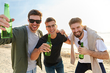 Image showing young men toasting non alcoholic beer on beach