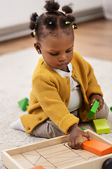 Image showing african baby girl playing with toy blocks at home