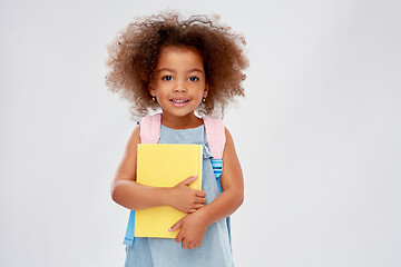 Image showing happy little african girl with book and backpack