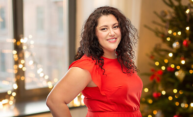 Image showing happy woman in red dress over christmas tree