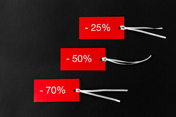 Image showing red tags with discount signs on black background