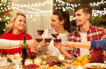 Image showing happy friends drinking red wine at christmas party