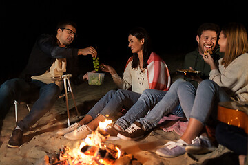 Image showing friends having picnic at camp fire on beach