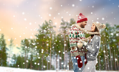 Image showing happy couple in ugly christmas sweaters in winter