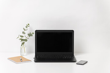 Image showing laptop with black screen on white office table
