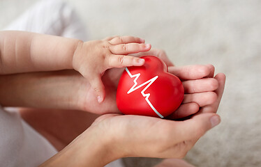 Image showing baby and mother holding red heart with ecg line