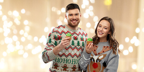 Image showing couple with cupcakes in ugly christmas sweaters