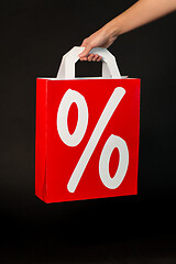 Image showing hand holding red shopping bag with percent sign