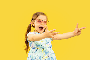 Image showing Beautiful emotional little girl isolated on yellow background