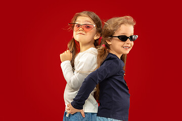 Image showing Beautiful emotional little girls isolated on red background