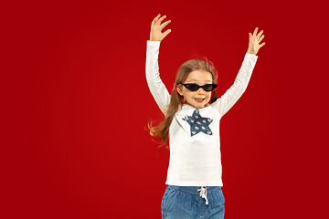 Image showing Beautiful emotional little girl isolated on red background