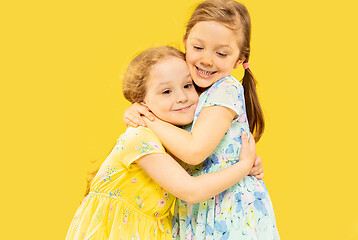 Image showing Beautiful emotional little girls isolated on yellow background