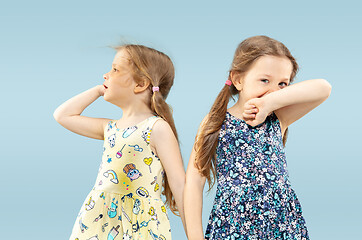 Image showing Beautiful emotional little girls isolated on blue background