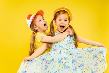 Image showing Beautiful emotional little girls isolated on yellow background