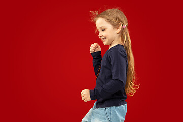 Image showing Beautiful emotional little girl isolated on red background