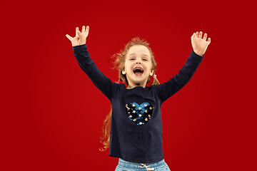 Image showing Beautiful emotional little girl isolated on red background