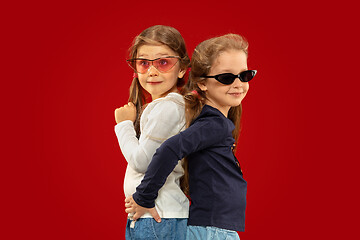 Image showing Beautiful emotional little girls isolated on red background