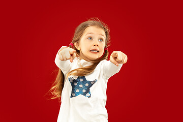 Image showing Beautiful emotional little girl isolated on red background