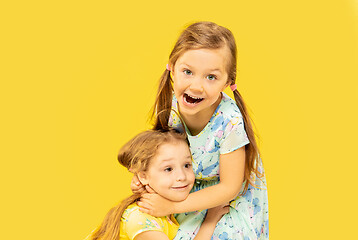 Image showing Beautiful emotional little girls isolated on yellow background