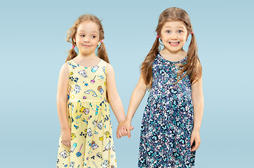 Image showing Beautiful emotional little girls isolated on blue background