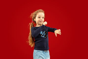 Image showing Beautiful emotional little girl isolated on red background
