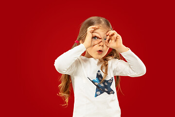 Image showing Beautiful emotional little girl isolated on red background