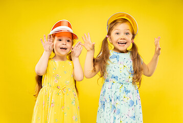 Image showing Beautiful emotional little girls isolated on yellow background