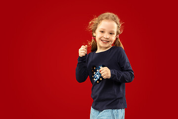 Image showing Beautiful emotional little girl isolated on red background