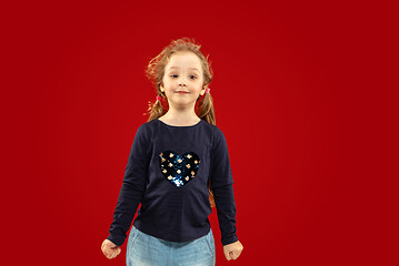 Image showing Beautiful emotional little girl isolated on red background