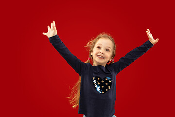 Image showing Beautiful emotional little girl isolated on red background