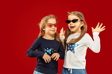 Image showing Beautiful emotional little girls isolated on red background