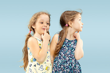 Image showing Beautiful emotional little girls isolated on blue background