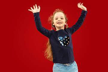 Image showing Beautiful emotional little girl isolated on red background