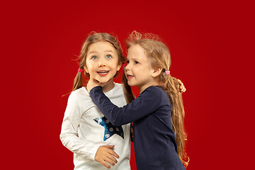 Image showing Beautiful emotional little girls isolated on red background