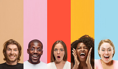 Image showing Young attractive people looking astonished on multicolored background