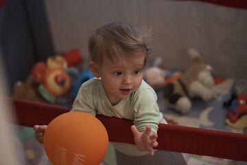 Image showing cute little baby playing in mobile bed