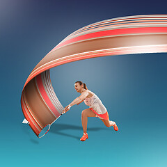 Image showing Full length portrait of young woman playing badminton isolated on blue background