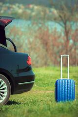 Image showing View of modern black car and suitcase on the river\'s side