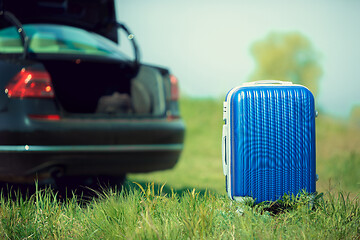 Image showing View of modern black car and suitcase on the river\'s side