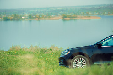 Image showing View of modern black car on the river\'s side