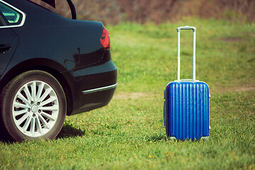 Image showing View of modern black car and suitcase on the river\'s side