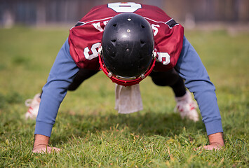 Image showing american football player doing push ups