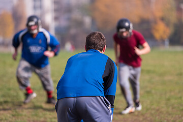 Image showing american football team with coach in action