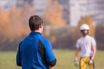 Image showing american football team with coach in action