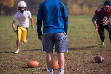 Image showing american football team with coach in action