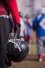 Image showing American football player holding helmet