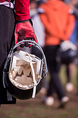 Image showing American football player holding helmet